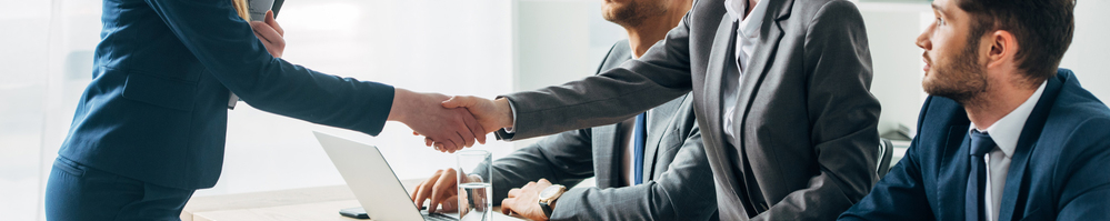 Business employees welcoming a new employee with a handshake