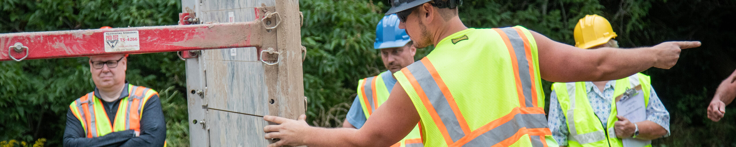 Men wearing construction vests and working.